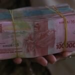 person holding 5000 indonesian rupiah